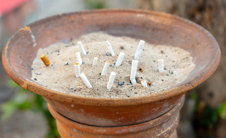 Cigarette butts in a sand bin.