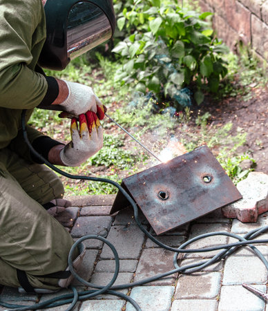 A welder welds metal at a construction site