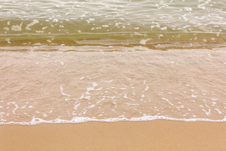 Yellow sand on the seashore as an abstract background. Texture.