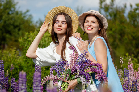 Two girls in lupine flowers.の写真素材