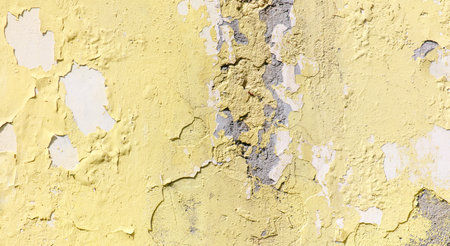 Cracked yellow paint on the wall as an abstract background. Texture.の写真素材
