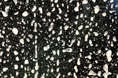 Dirt on the body of a black car. Abstract background.