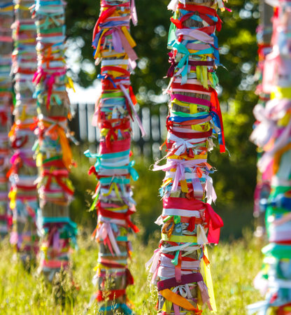 Multicolored ribbons hang on wooden poles. Religion.の写真素材