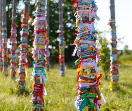 Multicolored ribbons hang on wooden poles.の写真素材
