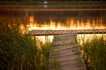 Wooden bridge on the lake at sunset.