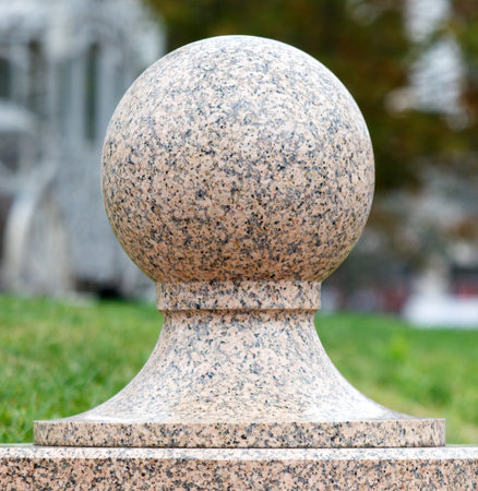A large stone ball sits on top of a stone base. The stone ball is round and has a smooth surfaceの写真素材