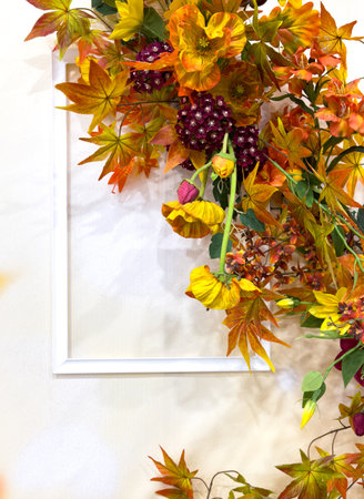 Autumn decoration with leaves and empty frames on the wall.