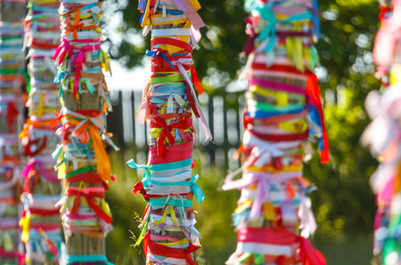 Multicolored ribbons hang on wooden poles.の写真素材