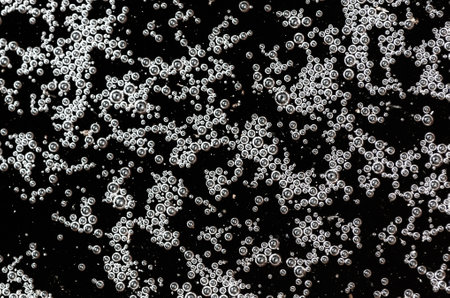Balls of air on the surface of the water as a background. Macro.
