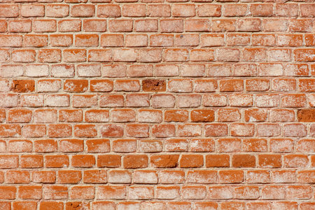A brick wall with a white spot on it. The wall is made of bricks