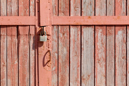 A rusty lock on a wooden door. The door is old and has a rustic appearanceの写真素材