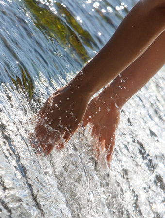 A person is reaching into a waterfall to touch the water.の写真素材