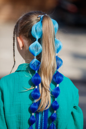 A woman with blue hair has a blue ponytail with blue beadsの写真素材