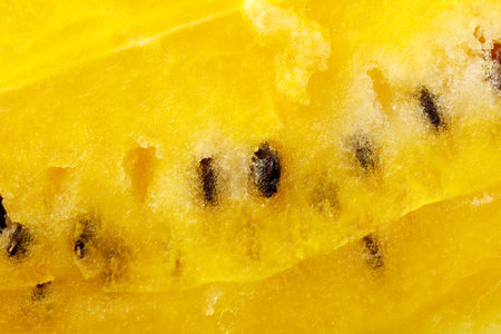 Yellow watermelon pulp with seeds as background. Macro.の写真素材