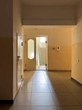 A hallway with a door that is open. The door is white and has a glass windowの写真素材