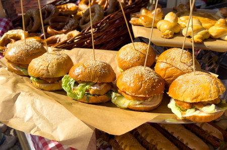 A table with a variety of sandwiches and rolls. The sandwiches are all different sizes and are held up by skewersの写真素材