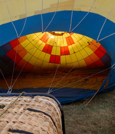A hot air balloon is open to show the inside of the balloon. The inside of the balloon is yellow, red, and blueの写真素材