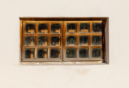 A window with wooden frames and glass panes. The window is open and the sunlight is shining through...