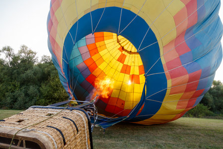 A hot air balloon with a fire in the bottom of it. The balloon is yellow and redの写真素材