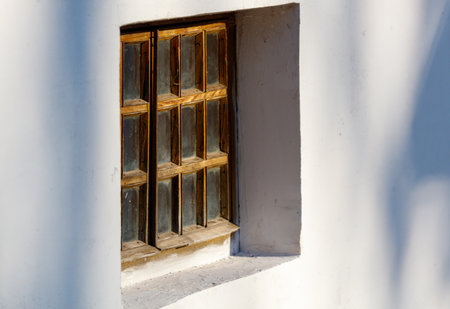 A window with a wooden frame and a glass pane. The window is open and the sunlight is shining...