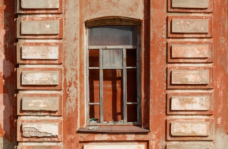A window with a wooden frame is open, and the view is of a brick wall. The window is dirty and has a...