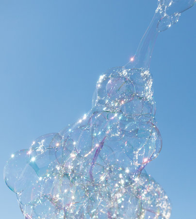 A bubble sculpture with a blue sky in the background. The bubbles are multi-colored and appear to be...