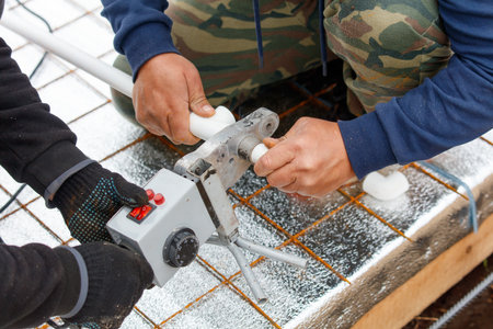 Two men are working on a project, one of them is holding a tool that looks like a small boxの写真素材