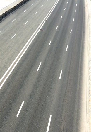 A long, empty highway with no cars on it. The road is wide and straight, with no visible obstacles