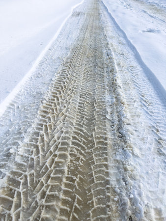 A snowy road with tire tracks in the snowの写真素材
