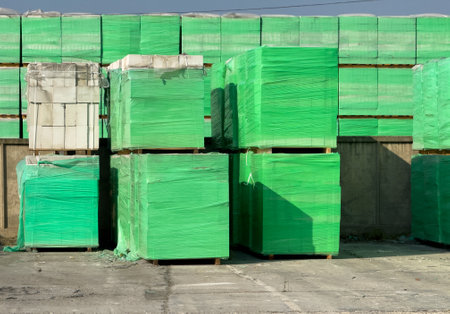 A pile of green boxes stacked on top of each other. The boxes are green and have a plastic coveringの写真素材