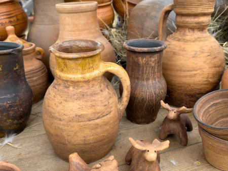 A collection of pottery, including a pitcher and a few other vases, sit on a tableの写真素材