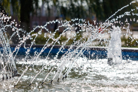 A fountain with water shooting out of it. The water is clear and the fountain is blue. The water is...