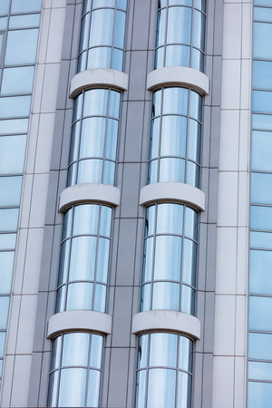 The building has a lot of windows and a very modern look. The windows are very clear and reflect the blue skyの写真素材