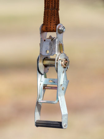 A piece of equipment with a chain attached to it. The chain is hanging from a hookの写真素材