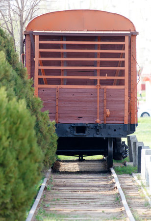 A train car with a wooden door sits on a track. The train car is old and rustyの写真素材