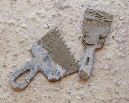 Two old tools laying on a cement floor. One of the tools is broken. The other tool is still in good conditionの写真素材