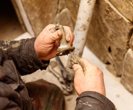 A man is holding a dirty pipe with his hands. Concept of manual labor and hard workの写真素材