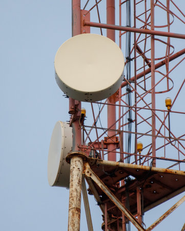 A tall red tower with a white antenna on top. The tower is made of metal and has a rustic...