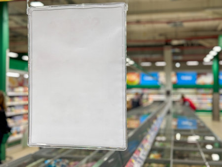 A white sign is hanging from a store window. The sign is empty and the store is busyの写真素材