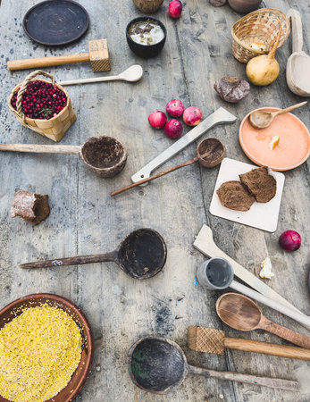 A table with many wooden spoons and bowls of various sizes.