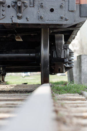 A train engine is shown with its wheels off the tracks. The train is parked on a track with a grassy area in the backgroundの写真素材