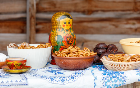 A table with a Russian doll and a variety of snacks. Scene is casual and inviting, as the snacks are laid out on a table for people to enjoyの写真素材