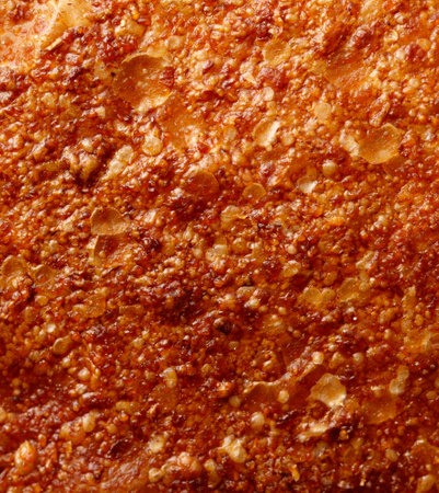 A close up of a piece of food with a lot of texture and a lot of brown spots. The food appears to be a type of fried dish, possibly a pizza or a pastryの写真素材