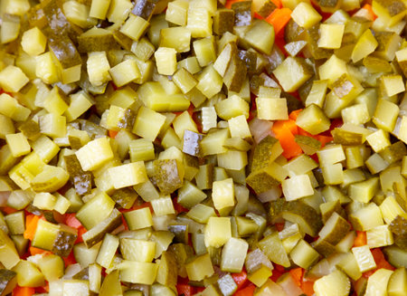 A close up of pickles and carrots. The pickles are green and the carrots are orange