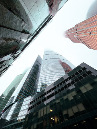 A city skyline with tall buildings and a cloudy sky. The buildings are mostly glass and the sky is overcastの写真素材