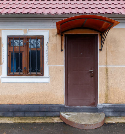 A brown door with a window above it. The door is closed and the window is open. The door is made of wood and the window is made of glassの写真素材