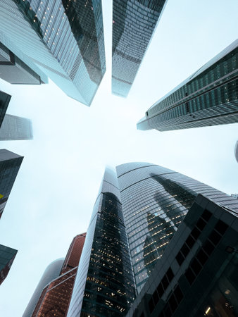 A city skyline with tall buildings and a cloudy sky. The buildings are all different heights and are spread out across the image. The sky is overcastの写真素材