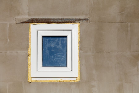 A window with a blue reflection on the wall. The window is white and has a yellow frame