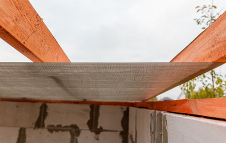 A wooden beam is above a cement wall. The beam is covered in a white material.の写真素材