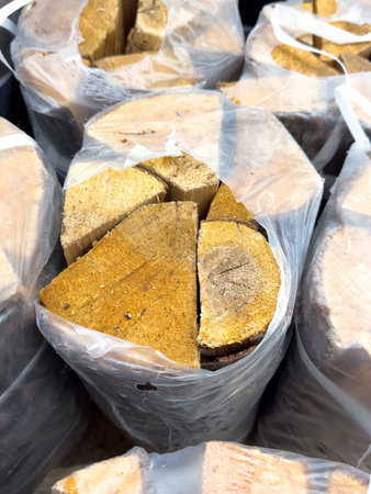 A pile of wood is wrapped in plastic bags. The bags are stacked on top of each other